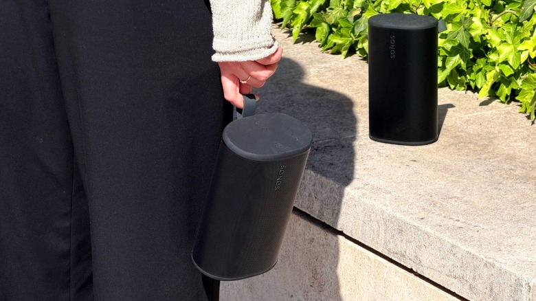 A woman holding Sonos Play speaker outdoors