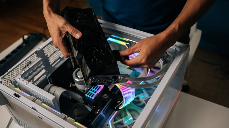 Hands putting together a gaming PC with its components