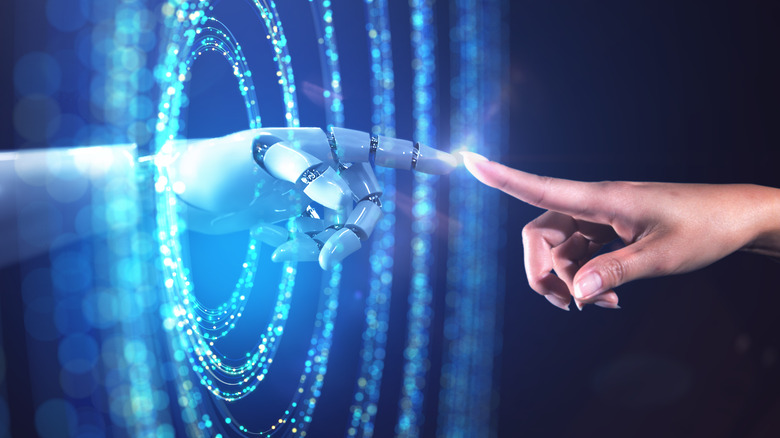 Woman's hand touching fingers with AI robot's hand