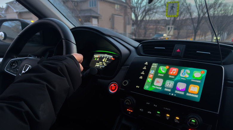 A driver with Apple CarPlay active in the car.