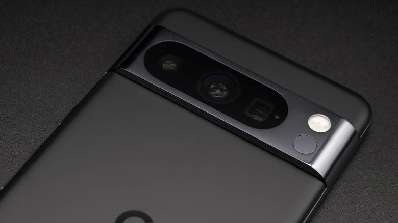 A black Google Pixel 8 sitting against a black surface