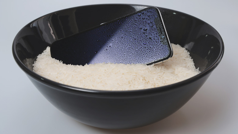 An iPhone placed in a bowl of rice