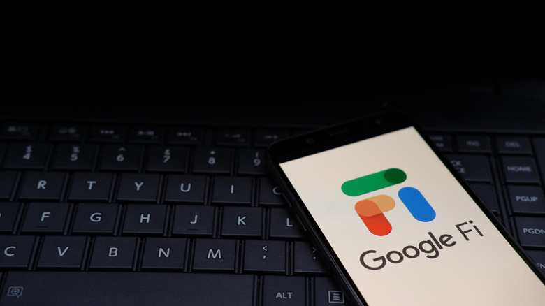 A smartphone with the Google Fi Wireless logo on it screen resting on a keyboard.