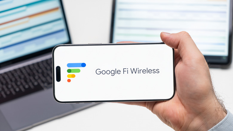A person holding a smartphone with the Google Fi Wireless logo on the screen.