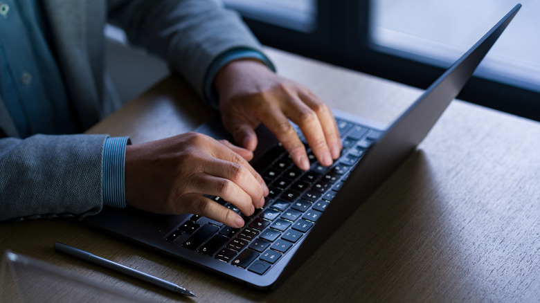 Man typing on a laptop computer