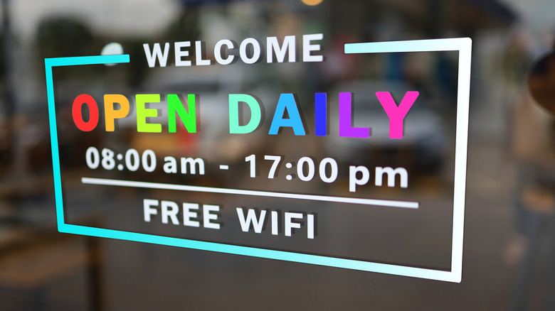 welcome sign on window with free Wi-Fi written at bottom, open daily, and hours of operations showing