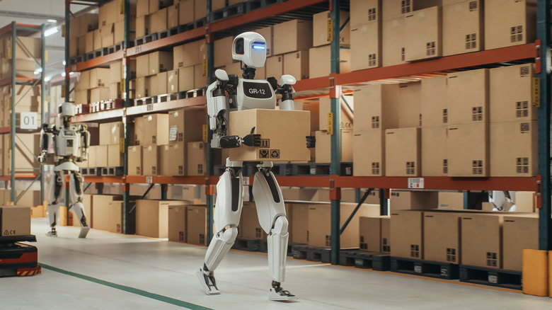Robotic Worker Walking with a Cardboard Box Inside a Warehouse in a Smart Factory