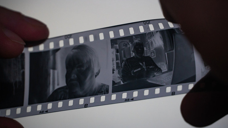 A person examining 35mm film.