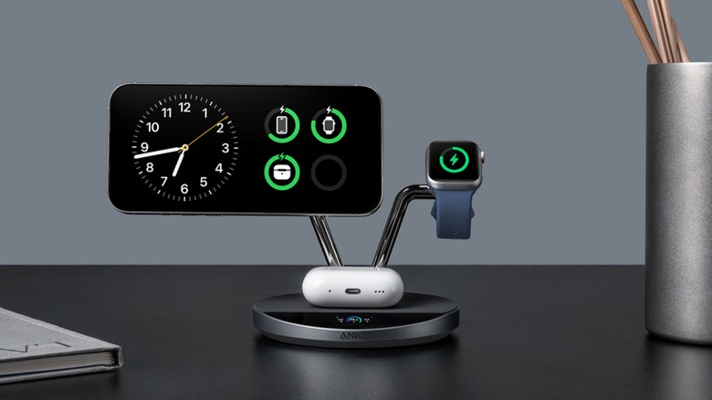 A smartphone, airpod case, and smartwatch charging on an Anker Prime Wireless Charging Station