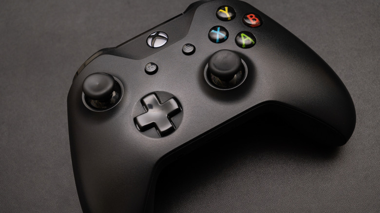 A black Xbox controller set against a gray backdrop.