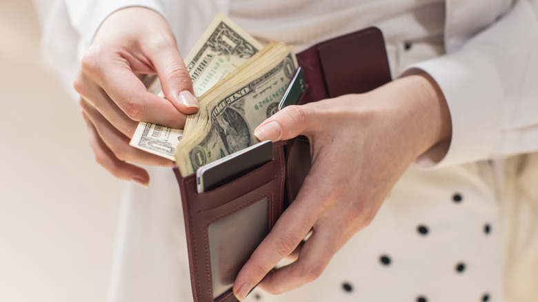 Close-up of a person handling cash in a wallet