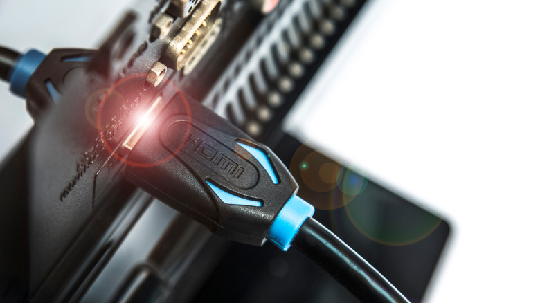 An HDMI cable plugged into a port on the back of a TV