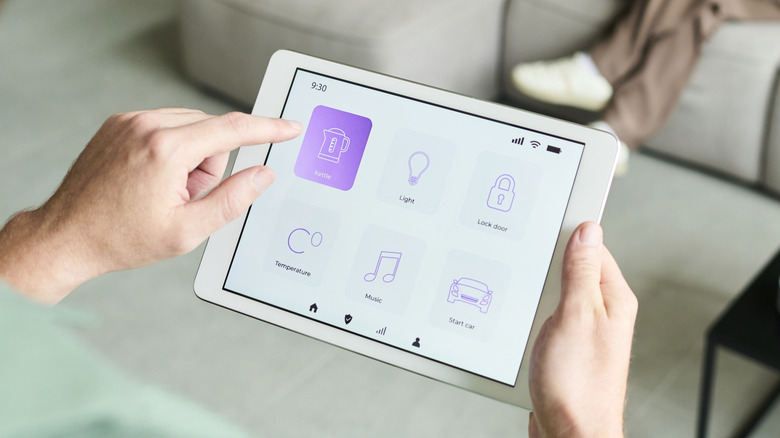 A person using a tablet to control a smart home.