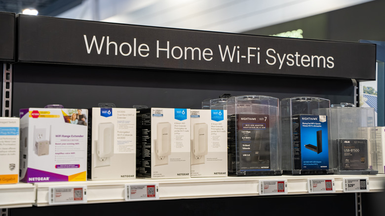 Whole home mesh Wi-Fi systems on a retail store shelf from varying brands.