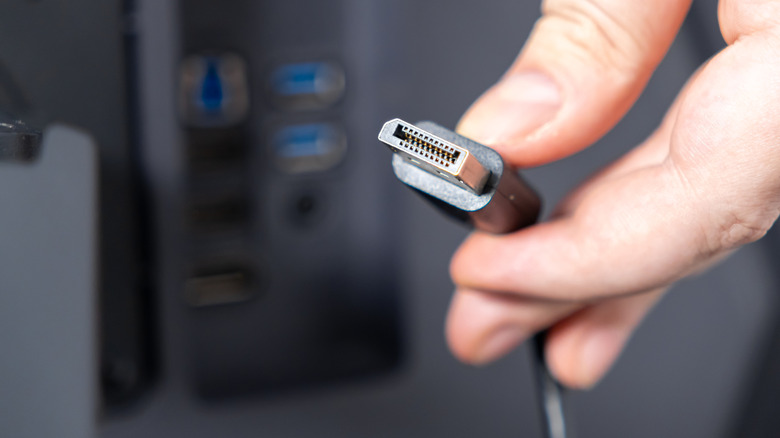 Person holding DisplayPort cable outside of PC IO shield.