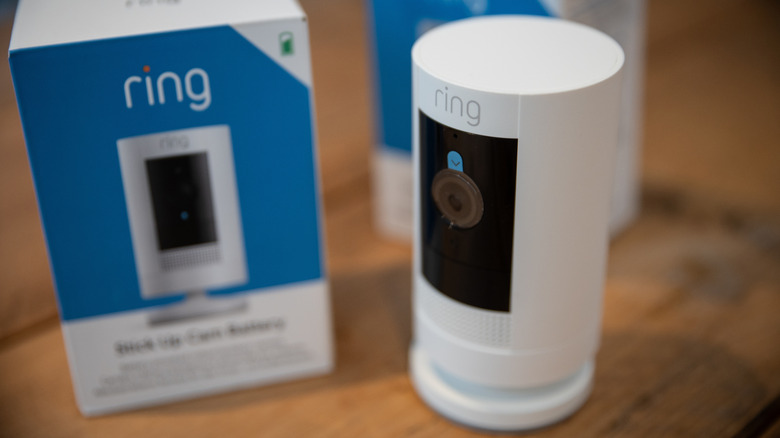 The Ring Stick Up Cam placed next to its product packaging on a flat surface.