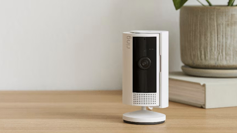 A Ring Outdoor Cam placed on a flat surface in an indoor space.