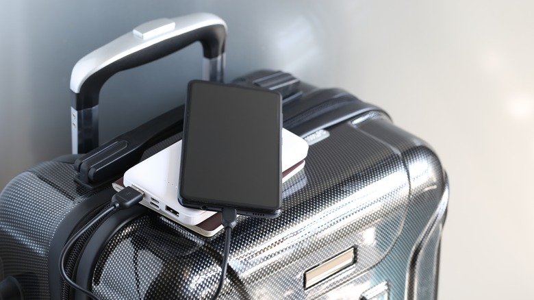 a power bank and phone placed on a carry-on suitcase