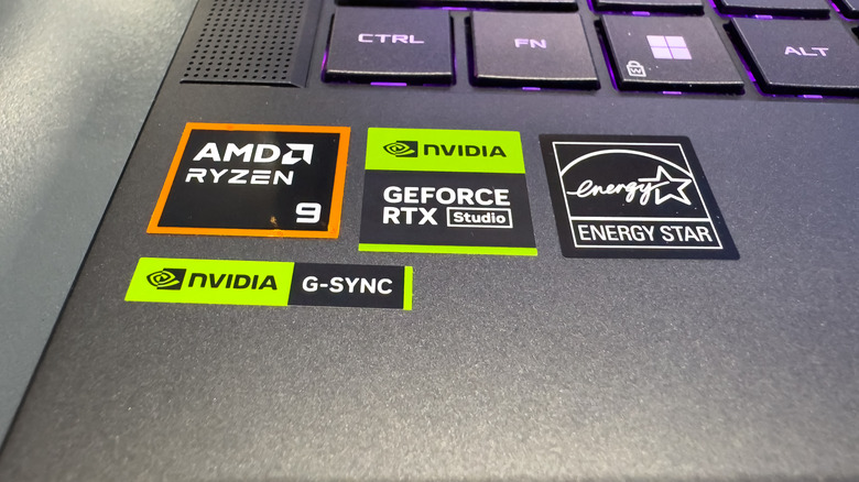 A photograph of a laptop showing the AMD Ryzen 9 CPU sticker and the NVIDIA GeForce RTX sticker.
