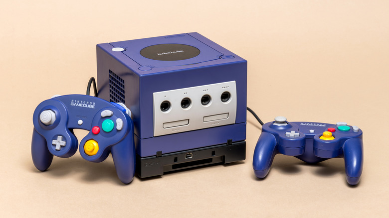 A GameCube console and controllers on a beige background