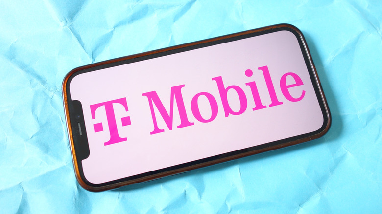 T-Mobile logo displayed on a smartphone screen against a blue background.