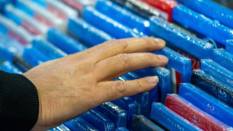 Someone looking through stacks of Blu-Ray discs.