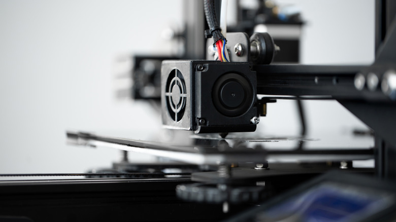 A 3D printer dispensing on a bed.