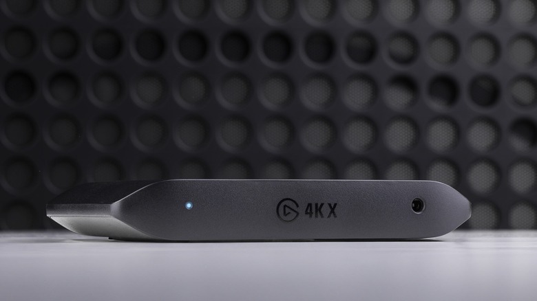 Elgato 4KX capture card in front of black screen with holes