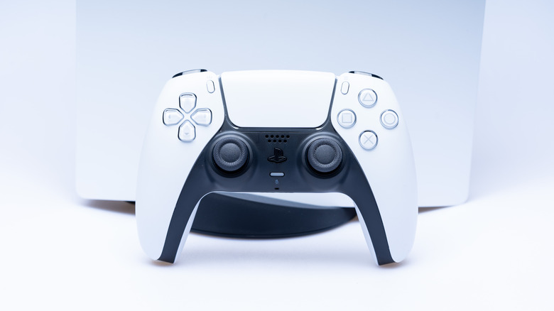 DualSense PlayStation 5 controller in front of the console on a white background