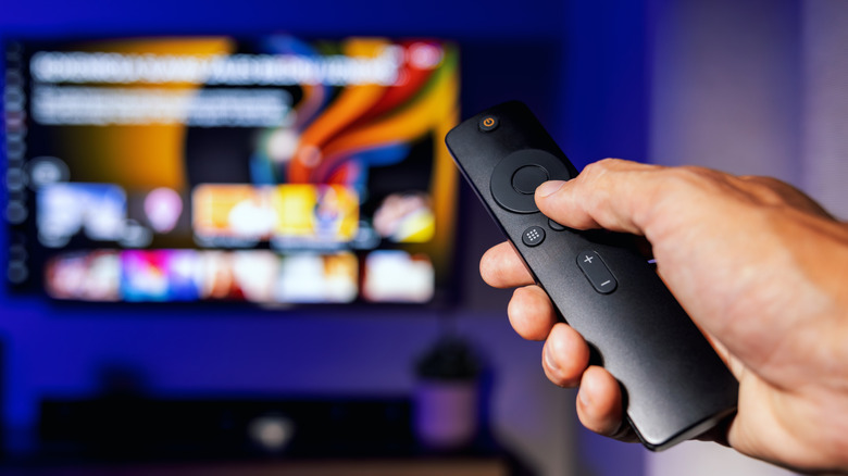 A person using a remote to control a smart TV.