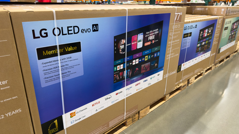 Several LG TV boxes stacked under shelving at a retail outlet