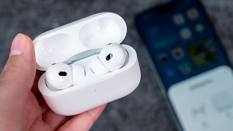 A person holding an AirPods Pro case. It's opened up and there are AirPods inside.