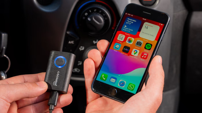 Person holding an iPhone and AAWireless TWO+ adapter