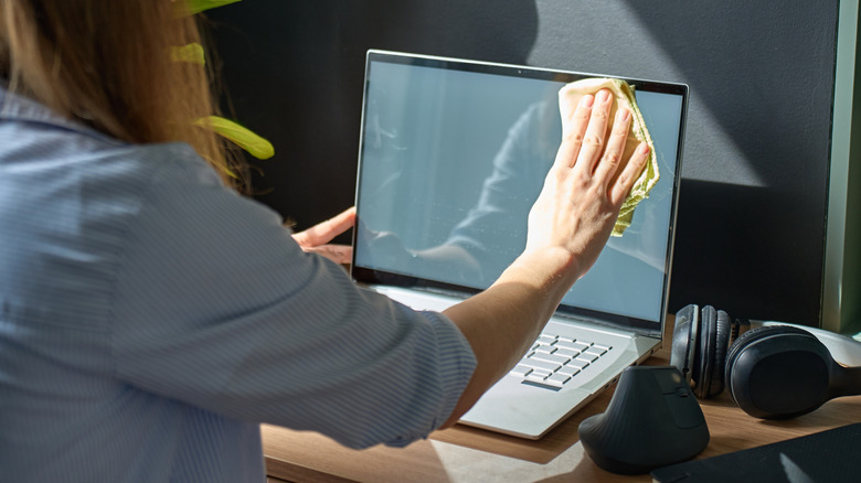 A person cleaning a monitor