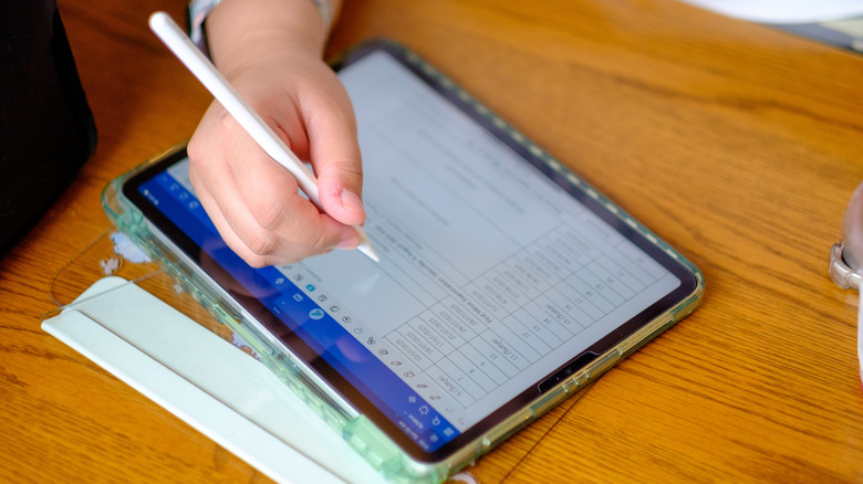 A person using the Apple Pencil to write in an iPad app.