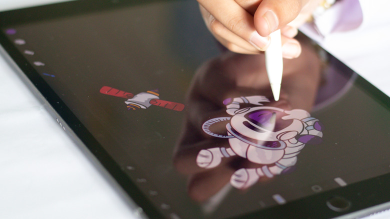 A person drawing on an iPad with an Apple Pencil.