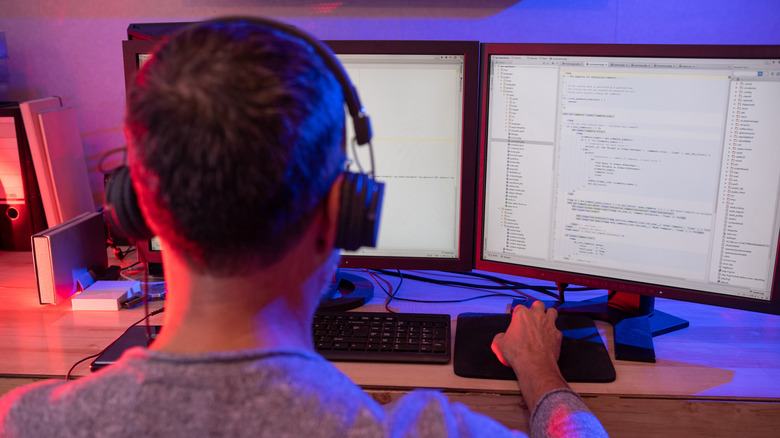 A developer coding on a pair of monitors