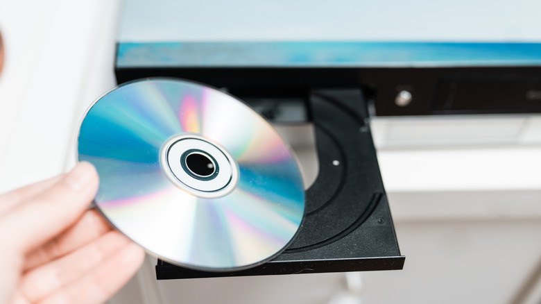 Person putting a DVD into a player