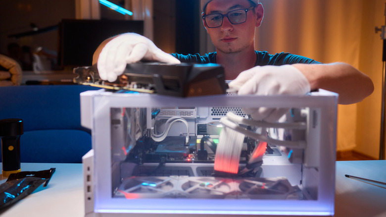 Someone installing a modern graphics card in a custom PC case.