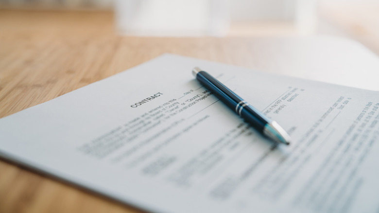 Contract on a desk with a pen on top.