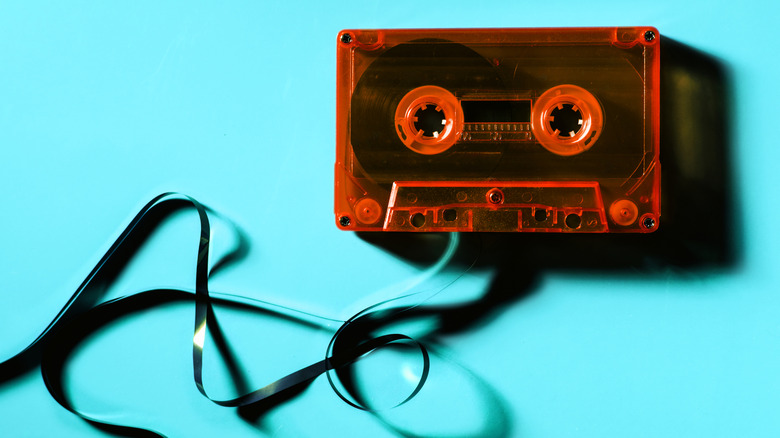 An orange cassette unspooled against a blue background