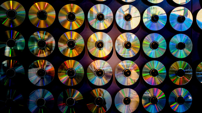 CDs lined up on a wall reflecting light