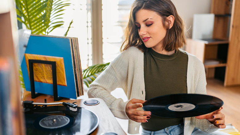 A young woman listening to vinyl records.