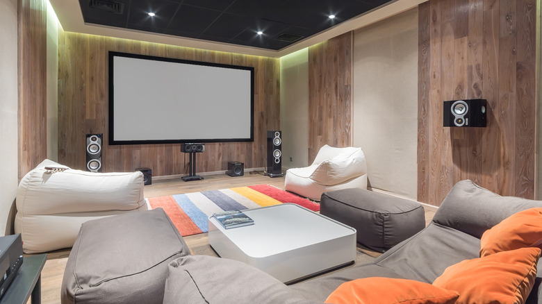 Home theater room with a large projection screen, speakers, and beanbag seating.