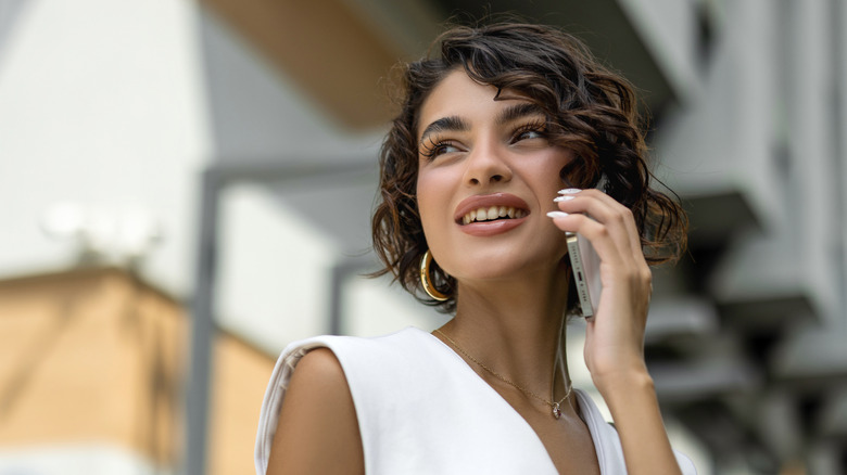 A woman looking into the distance while talking on a smartphone
