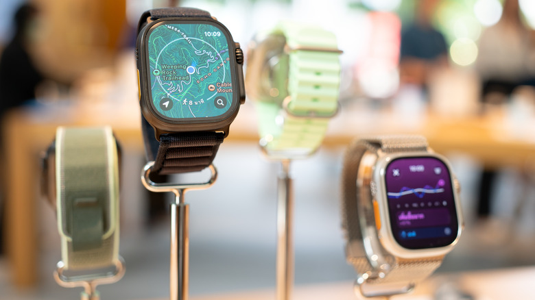 Several different Apple Watch models on display in a retail setting
