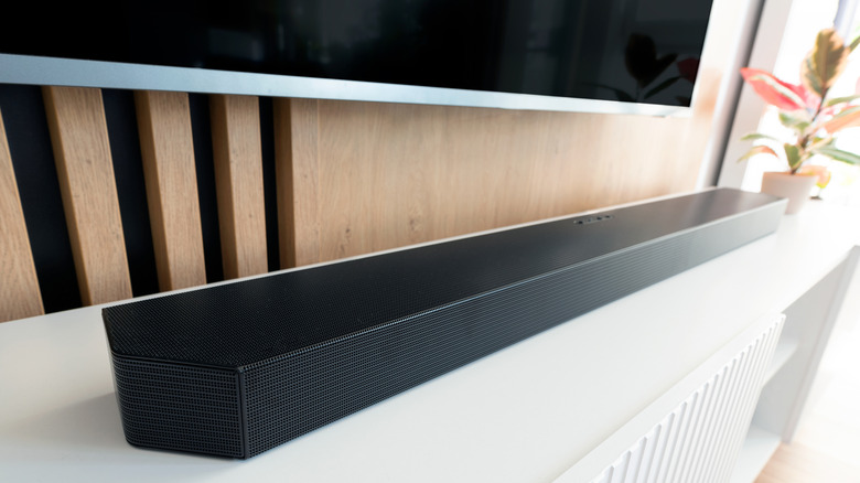 A home theater soundbar set up below a wall-mounted TV.