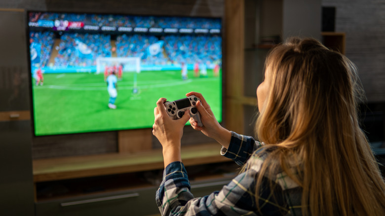 a person playing a football game with a controller in their hand