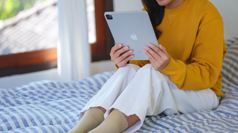 Woman reading iPad in bed