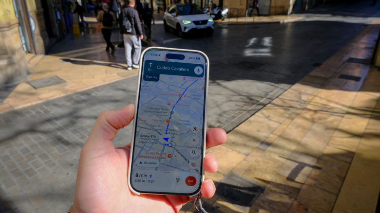 A person using navigation while walking, with the location indicator seen on the screen.
